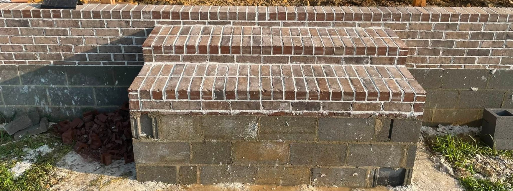 Brick stoop with rowlock treads built into a running knee wall
