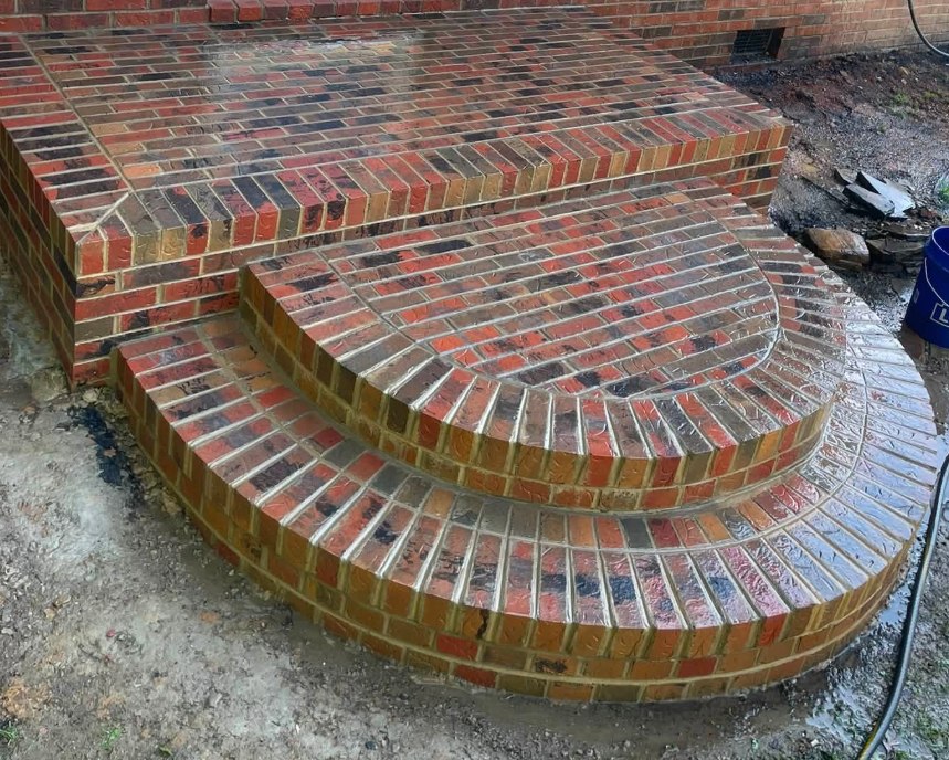 Finished curved brick steps with radial rowlock treads, photographed wet