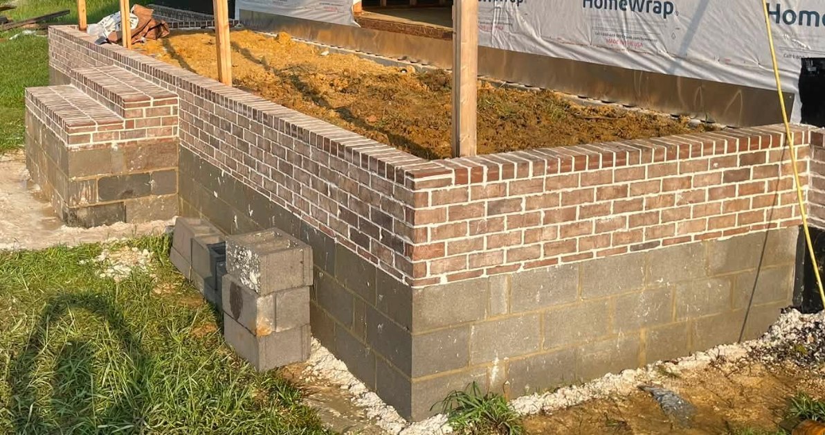 Brick veneer over block foundation with a rowlock-capped porch knee wall